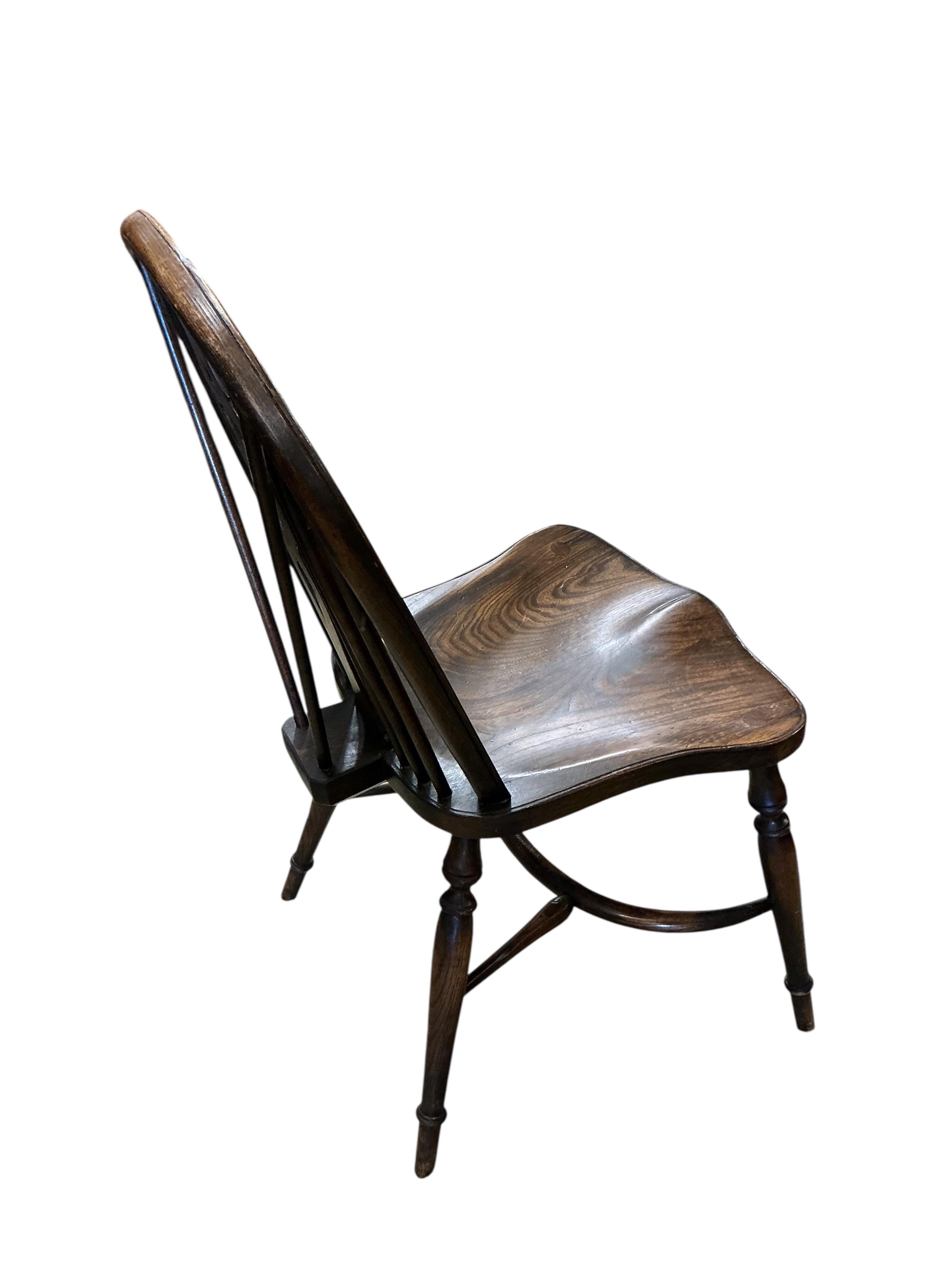 A set of ten reproduction Windsor elm and beech dining chairs with pierced splats and crinoline stretchers, two with arms